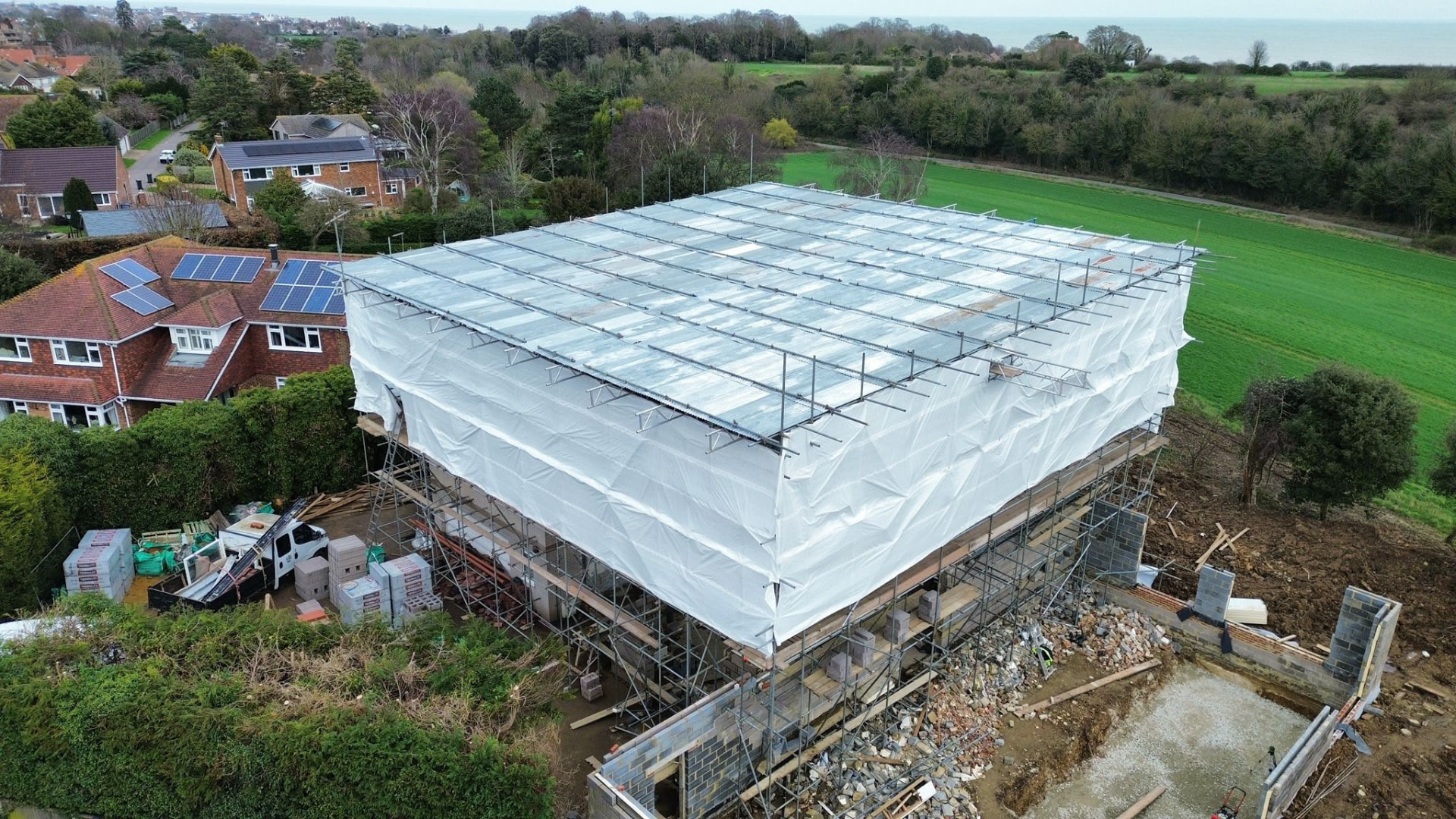 Aerial view of a temporary roof scaffold keeping a rebuild watertight